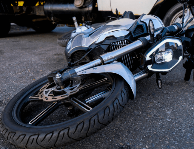 Close-up motorcycle front wheel after city street car crash showing the need for motorcycle accident laws